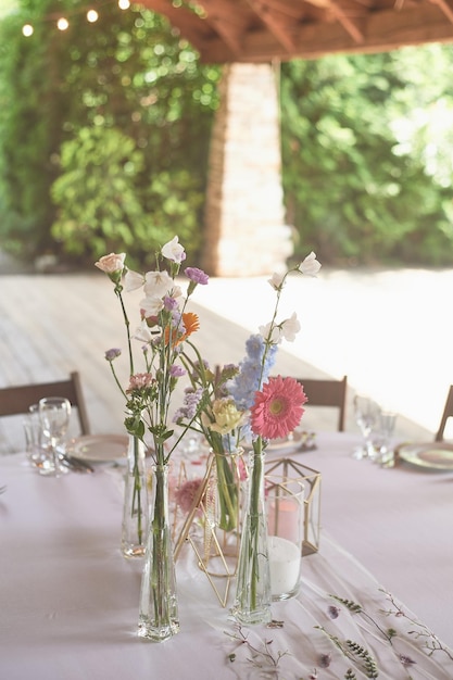 Floristique Décoration florale du mariage aux couleurs pastel Beaucoup de fleurs dans différents vases et récipients