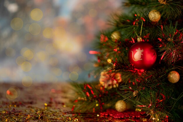 Flou abstrait. Boule de Noël rouge avec simbol du nouvel an sur un fond de bokeh d'arbre.