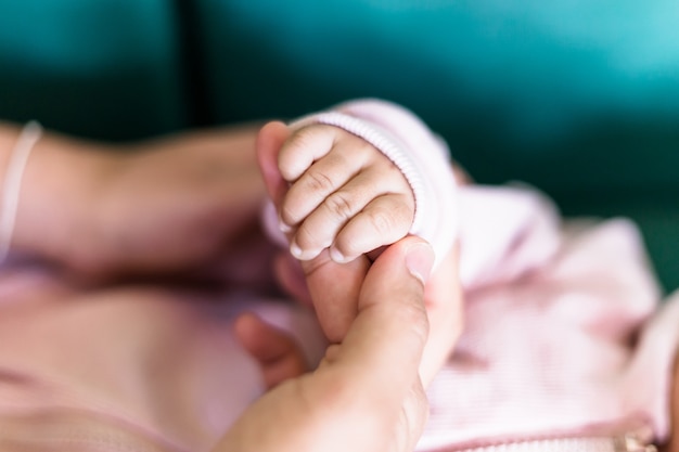 Flou artistique des mains de bébé et de maman, Nouveau concept de protection de la famille et du bébé, Main de bébé tenant doucement le doigt de l'adulte, Mère utilise sa main pour tenir la petite main de son bébé pour lui faire sentir son amour