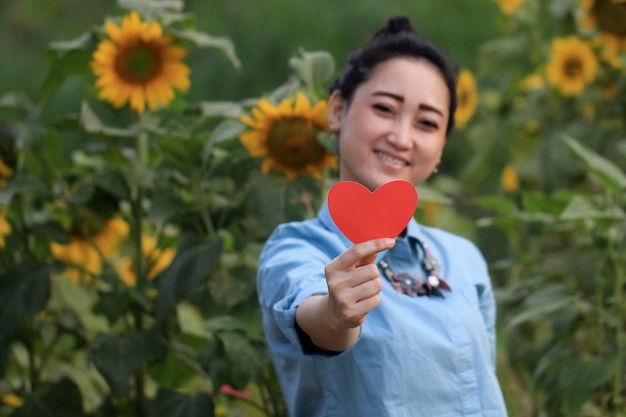 Flou de belle femme tenant le symbole de l'amour dans sa main