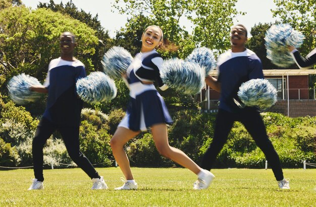 Flou de l'équipe de pom-pom girls et portrait de personnes en spectacle de danse sur le terrain en plein air pour la formation ou l'entraînement Groupe de cheerleading souriant et soutien lors de compétitions sportives et d'énergie