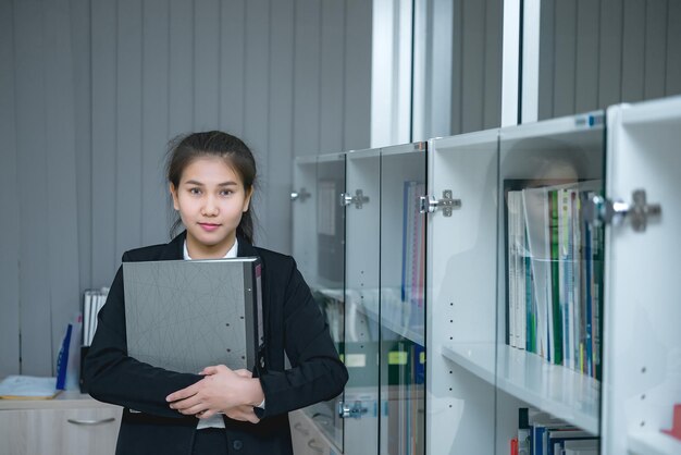 Flou d'une femme officier asiatique avec un fichier de documents dans sa mainles gens d'affaires ont un beau sourireles gens de la thaïlande travaillent beaucoup