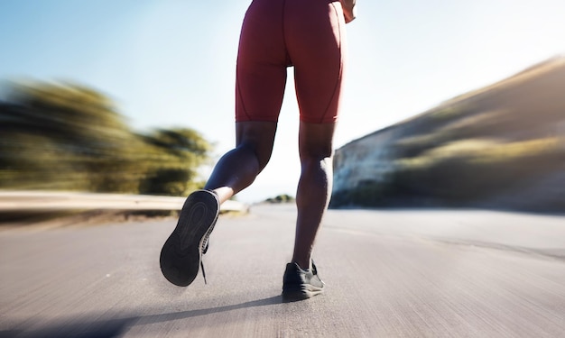 Flou de mouvement femme et jambes courant sur la route pour l'exercice d'entraînement de marathon et l'entraînement sportif