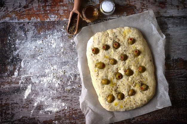 Focaccia italienne aux olives avant la cuisson.