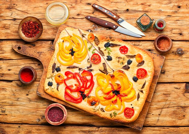 Focaccia italienne maison avec poivrons, tomates, basilic et olives.