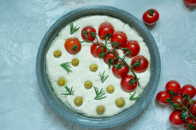 Focaccia italienne traditionnelle avec tomates, olives et romarin