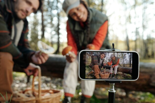 Photo focus sur l'écran du smartphone avec un jeune couple interculturel