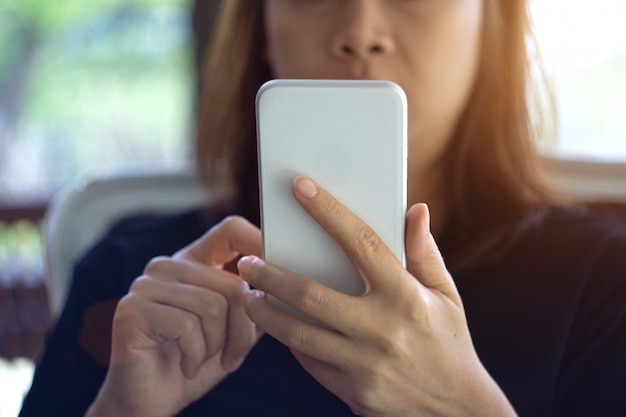 Focus main de jeune femme asiatique touchant le téléphone