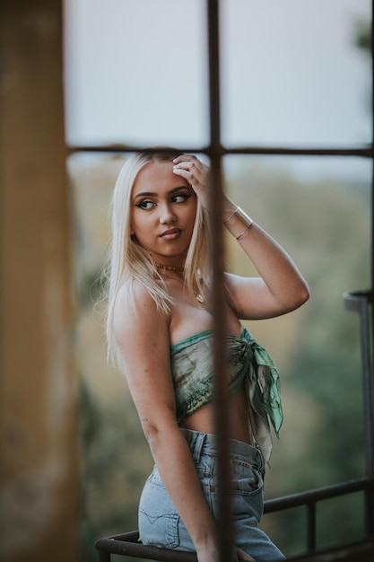 Focus superficiel d'une femme blonde sexy portant un crop top et posant dans un bâtiment abandonné