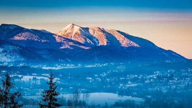 Foggy Zakopane et pic éclairé à l'aube en hiver Tatras Pologne