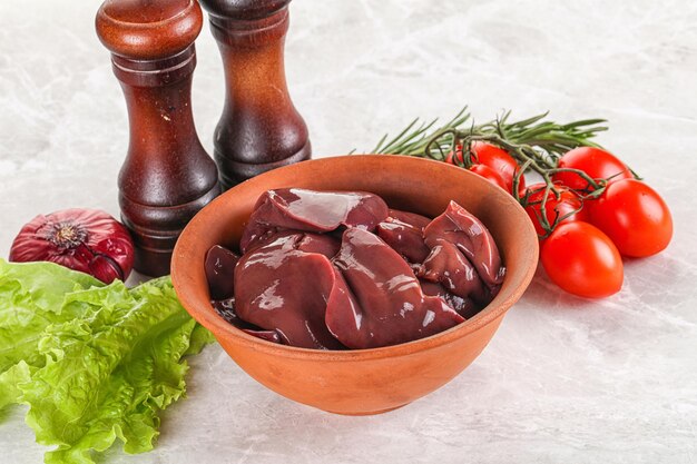 Foie de dinde cru dans un bol prêt à cuisiner avec des herbes et des épices