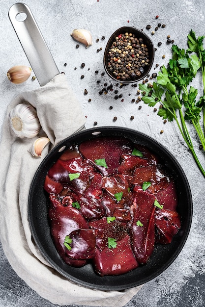 Foie de dinde cru dans une poêle. Vue de dessus