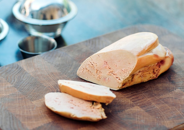 Photo foie gras d'oie sur une planche de bois au restaurant avant la cuisson.