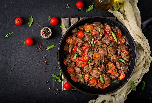 Foie de poulet (abats) avec oignons et tomates dans une poêle à frire en arménien