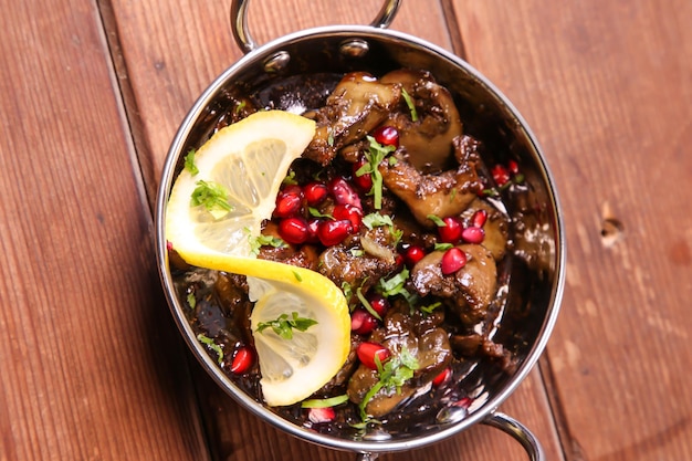 Foie de poulet épicé au citron vert et graines de grenade servi dans un plat isolé sur fond vue de dessus de mezza chaud