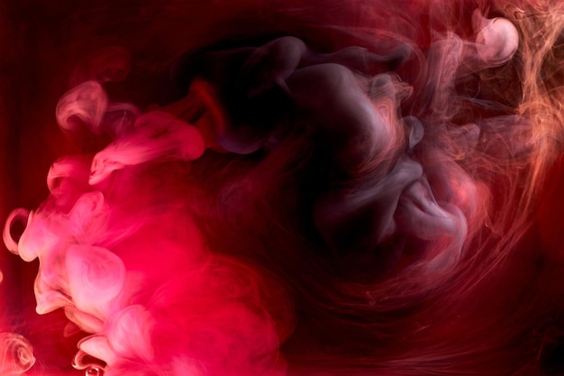 Fond abstrait d'encre tourbillonnante de pigment noir rouge, peinture de fumée liquide sous l'eau