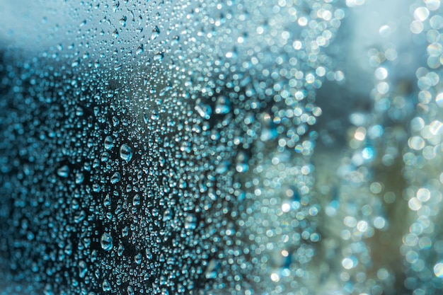 Fond abstrait avec des gouttes de pluie et un beau bokeh bleu