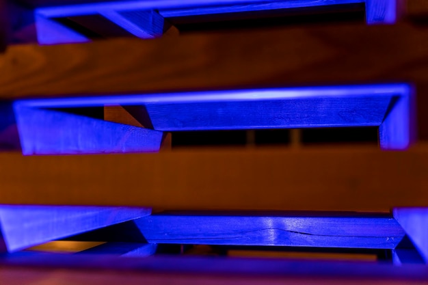 Fond abstrait de lattes de bois illuminées de néons bleus