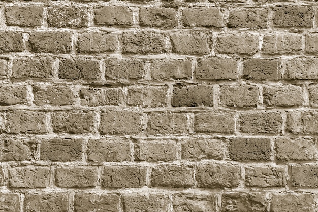 Le fond de l'ancien papier peint de mur de brique beige