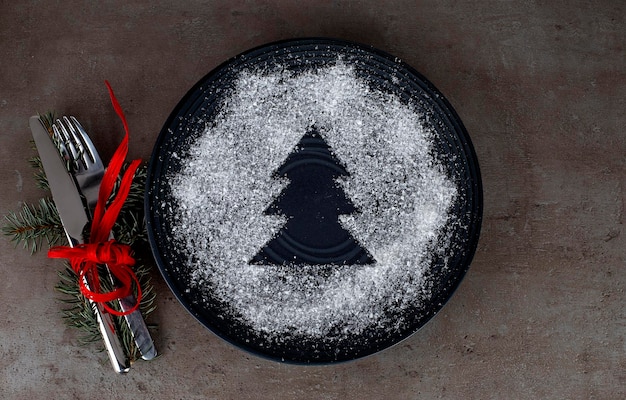 Fond, assiette et décor du dîner de Noël sur la table sombre, vue de dessus