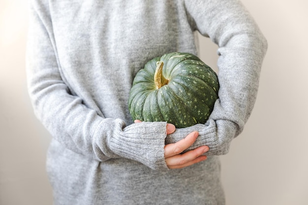 Fond automnal femme méconnaissable main tenant dans les mains automne automne citrouille isolé sur blanc