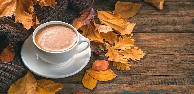 Fond d'automne avec tasse à café et feuillage Composition d'automne confortable