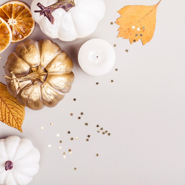 Fond d'automne ou de thanksgiving Composition de feuilles de citrouilles dorées et de placers d'étoiles de confettis