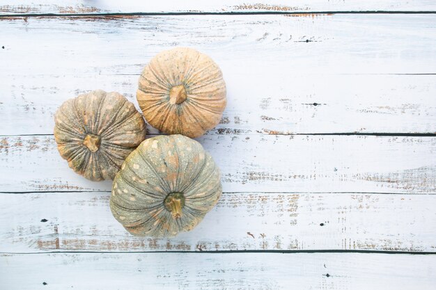 Fond d'automne et de Thanksgiving à partir de feuilles mortes et de fruits citrouilles sur table en bois