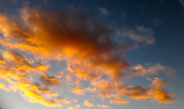 fond avec beaucoup de nuages jaunes et oranges sur ciel bleu