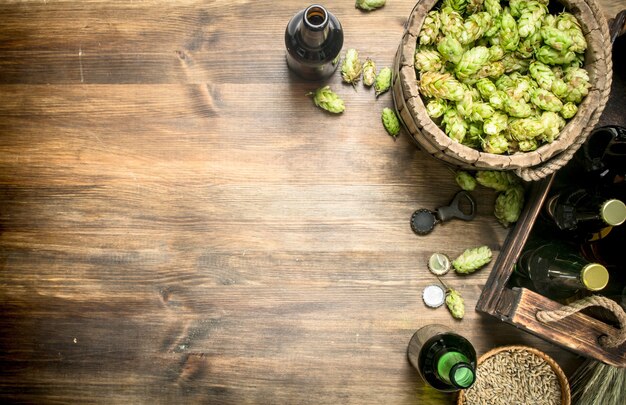 Fond de bière Bière en bouteilles et ingrédients sur une table en bois