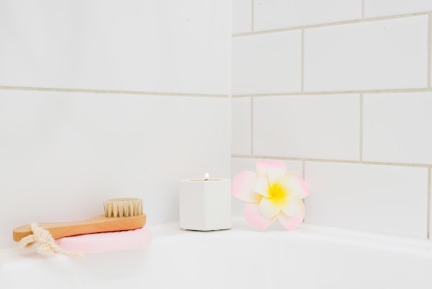 Fond blanc Bougie de bain Fleur de Plumeria Bambou Visage Brosse SPA à la maison Concept Horizontal