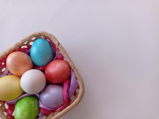 sur fond blanc panier oeufs colorés