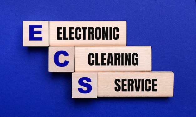 Sur un fond bleu clair, des blocs et des cubes en bois clair avec le texte ECS Electronic Clearing Service