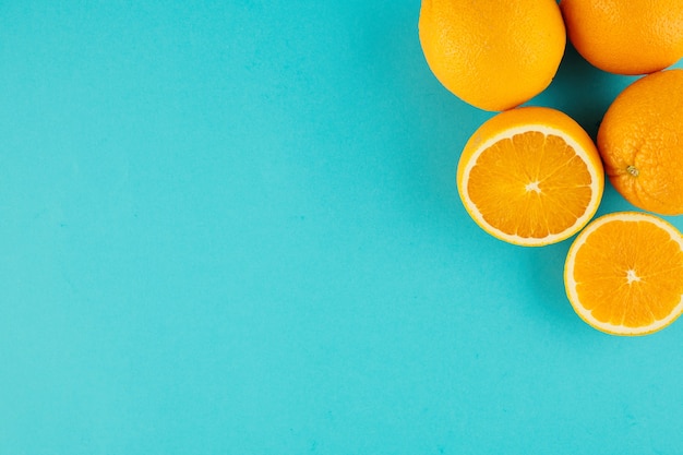 Fond Bleu Clair Avec Des Oranges Coupées Et Non Coupées Dans Le Coin Supérieur Droit