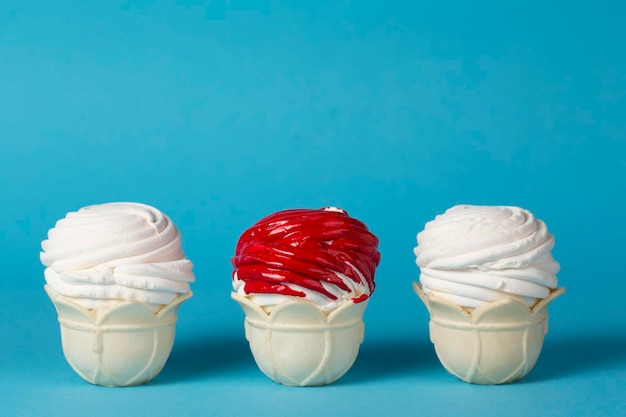 Photo sur un fond bleu deux blancs et un gâteau rouge dans une tasse à gaufres belle nourriture créative