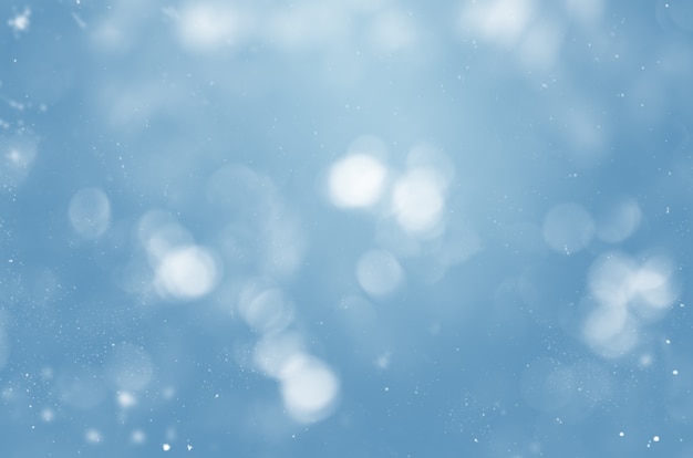 Fond bleu flou avec des flocons de neige et bokeh