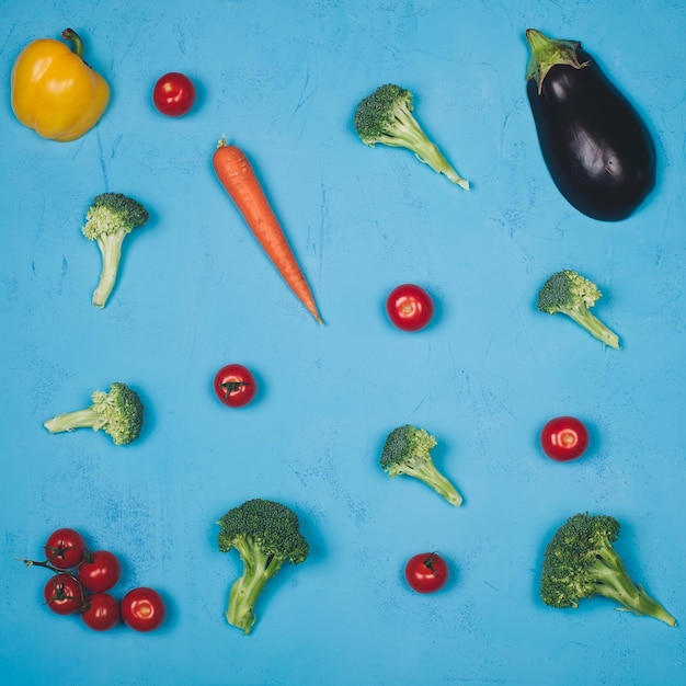 Photo un fond bleu avec des légumes et une aubergine jaune.