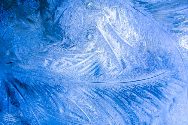 Fond bleu de Noël avec motif gelé sur la fenêtre