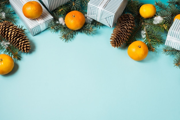 Photo fond bleu de noël avec sapin et mandarines.