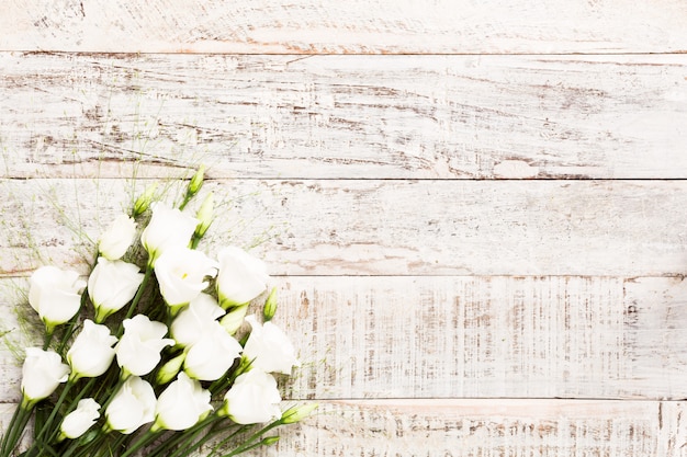 Fond en bois avec bouquet de fleurs blanches