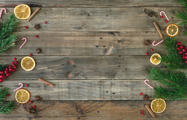 Fond en bois avec des décorations de Noël et des tranches d'orange déshydratées. Vue de dessus.