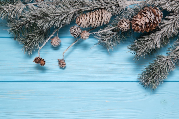 Fond en bois décoré avec des branches d'arbres de Noël.