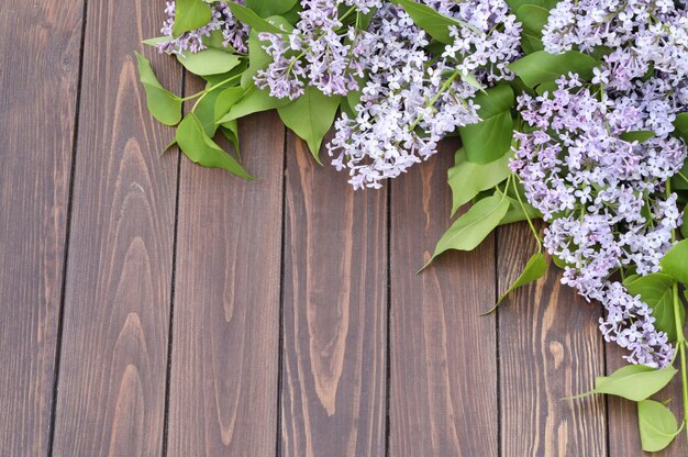 fond en bois marron avec cadre de fleurs lilas