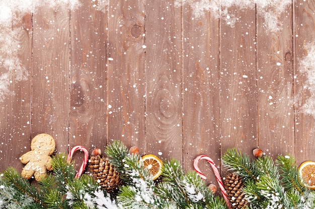 Fond en bois de Noël avec sapin de neige et décor de nourriture. Voir avec espace de copie