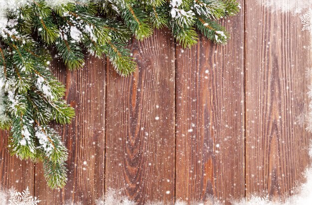 Fond en bois de Noël avec sapin de neige. Voir avec espace de copie