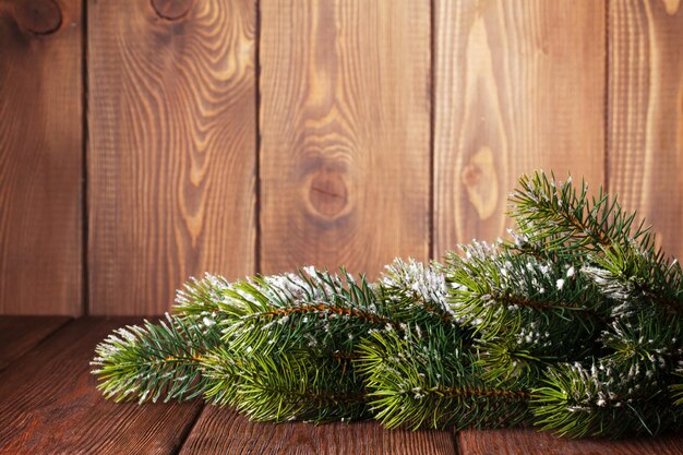 Fond en bois de Noël avec sapin de neige.