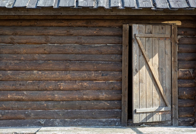 Fond en bois avec une porte. Vieux mur en bois d'une maison rustique avec texture et porte