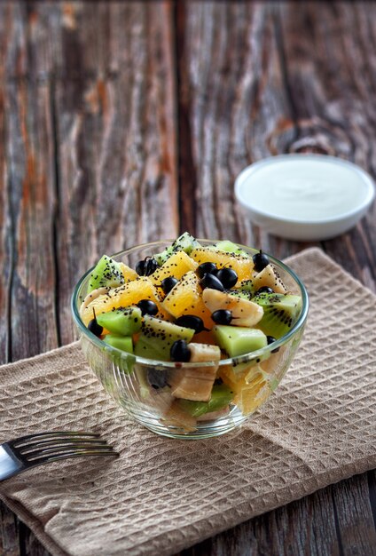 Sur un fond en bois, salade de fruits frais pour une alimentation saine