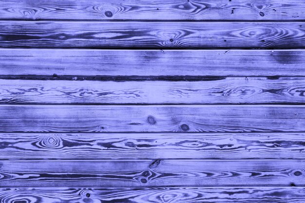 Fond en bois. Vieillissement des planches par cuisson et brossage. Un beau fond naturel universel composé de planches texturées de couleur violette tendance Very Peri. espace de copie. Photo de haute qualité