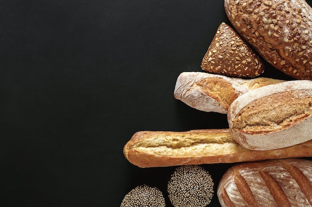 Fond de boulangerie, assortiment de pain isolé sur fond noir. Vue de dessus avec espace de copie